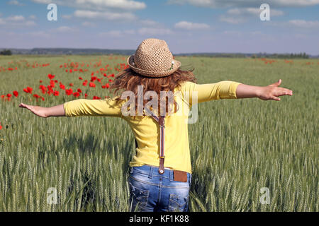 Petite fille court à travers un champ de blé vert Banque D'Images