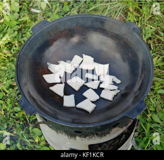 Pilaf de faire, vous devez d'abord faire revenir le gras de la ram dans un pot en fonte. automne journée ensoleillée piscine shot Banque D'Images