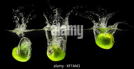 Tomber dans l'eau de pomme verte sur fond noir Banque D'Images