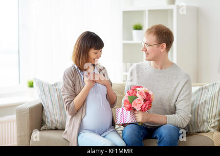 Heureux mari présent donnant à sa femme enceinte Banque D'Images