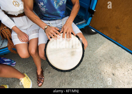 Close up of hippie amis jouant du tambour tom-tom Banque D'Images