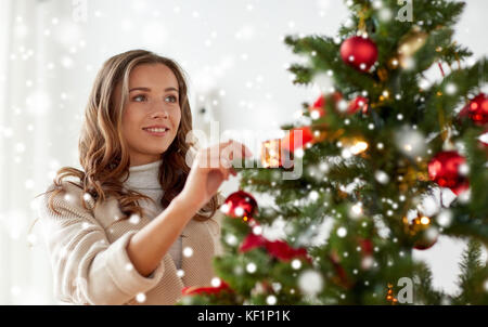 Happy young woman decorating Christmas Tree Banque D'Images