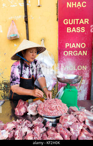 Coupe femme vietnamienne porc dans une boucherie dans une échoppe de marché dans la région de cholon de Ho chi minh ville.