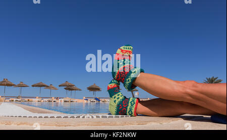 Chaussette de noël on palm tree at beach tropical exotique. maison de concept pour le nouvel an. Les cartes sur une chaussette de Noël de jolies jambes ensoleillée à l'arrière Banque D'Images