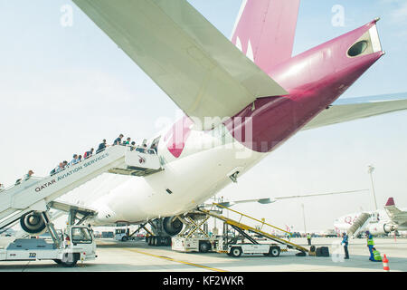 Leur embarquement sur un vol avion Boeing Qatar Hamad à l'Aéroport International. Banque D'Images