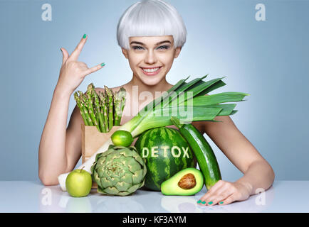 Fashion girl avec une abondance de fruits et légumes. photo de smiling blonde girl geste montrant 'cool' est un mode de vie sain concept. Banque D'Images