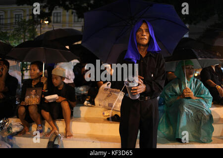 Bangkok, Thaïlande. 24 Oct, 2017. Malgré les fortes pluies du mardi soir. Les gens commencent à faire la queue et dormir dans shop des portes et dans les rues la nuit pour assister à la fin de la Thaïlande le Roi Bhumibol Adulyadej et la crémation de la cérémonie funèbre au Palais Royal. Credit : Panupong Changchai/Pacific Press/Alamy Live News Banque D'Images