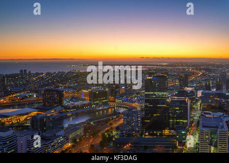 Une vue aérienne de la ville y compris la rivière Yarra Melbourne et Victoria Harbour dans la distance pendant le coucher du soleil avec de beaux rayons du soleil éclatant à travers Banque D'Images