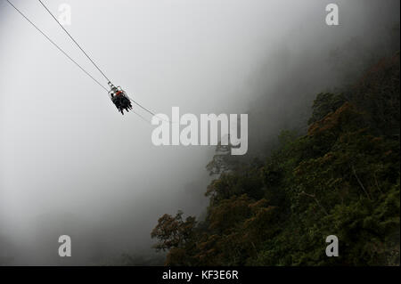Les touristes glisse sur le zip line à une montagne dans le contexte de la forêt tropicale, mindo, Equateur Banque D'Images
