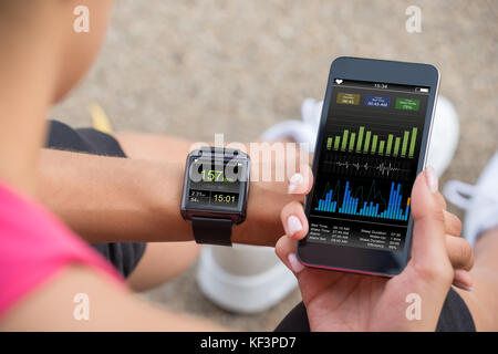 Coureuse à à son mobile et Smart Watch Moniteur de fréquence cardiaque Banque D'Images