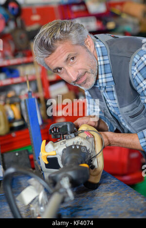 Homme mûr la réparation de machine whacking de mauvaises herbes Banque D'Images