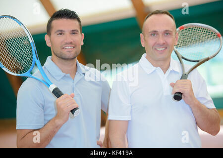 Deux hommes avec des raquettes de tennis sur leurs épaules Banque D'Images