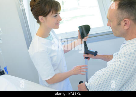 Doctor helping patient avec la béquille Banque D'Images