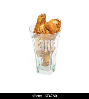 Pilons de poulet frit et les ailes dans un verre isolé sur fond blanc Banque D'Images