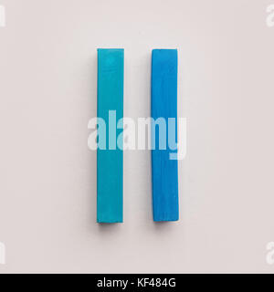 Deux morceaux de craie crayon pastel bleu sur fond blanc isolé Banque D'Images