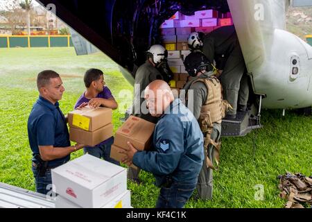Les Marines des États-Unis et les volontaires locaux déchargent des fournitures d'urgence d'un avion MV-22 Osprey de l'US Navy lors des opérations de secours à la suite de l'ouragan Maria le 27 septembre 2017 à Jayuya, Porto Rico. Banque D'Images