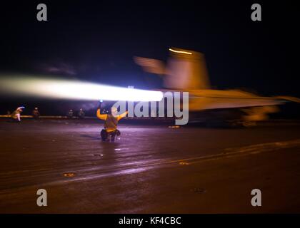 Un avion de chasse à réaction F/A-18F Super Hornet de l'US Navy décolle du pont d'envol du porte-avions USS Nimitz de classe Nimitz de l'US Navy dans la nuit du 5 octobre 2017 dans le golfe Persique. Banque D'Images