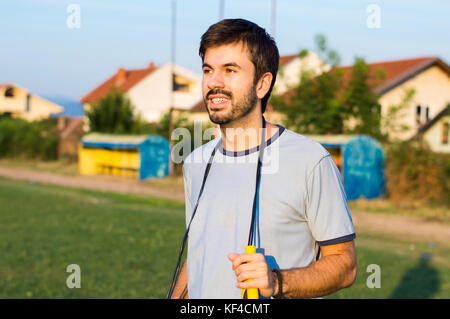 L'exercice de l'homme avec la corde à sauter à un stade Banque D'Images