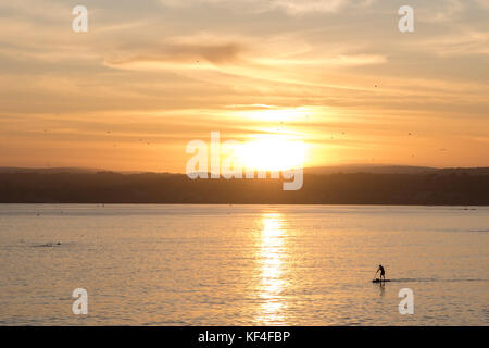 Paddle boarder au coucher du soleil à Cornwall, Royaume-Uni Banque D'Images