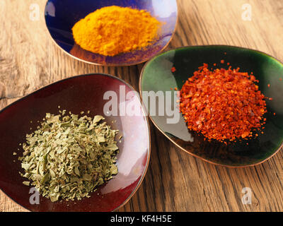 Assortiment de différentes épices colorées dans des bols de cuivre sur une table en bois rustique Banque D'Images