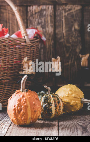 Décorations accueil chaleureux de l'automne. Nature morte avec panier en osier, bougies, mini potirons et red-vérifié serviette dans un style rustique Banque D'Images