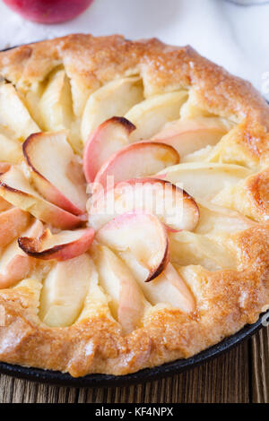 Tarte aux pommes faite maison cuit dans une poêle sur une table en bois rustique Banque D'Images