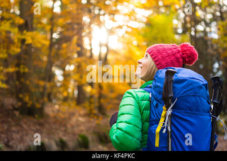 Sac à dos randonnée femme avec à la recherche d'inspiration à l'automne de la forêt d'or. Voyage de remise en forme et d'un style de vie sain à l'extérieur en saison d'automne, la nature. Femme Banque D'Images