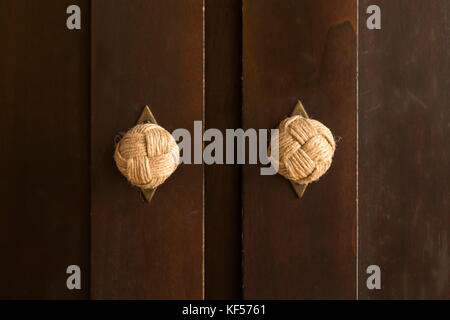 Poignées de porte sur une vieille armoire en bois ou une armoire avec panneaux soulevés Banque D'Images