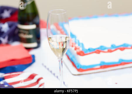 Verre de champagne sur la table avec un gâteau en arrière-plan au rassemblement électoral Banque D'Images