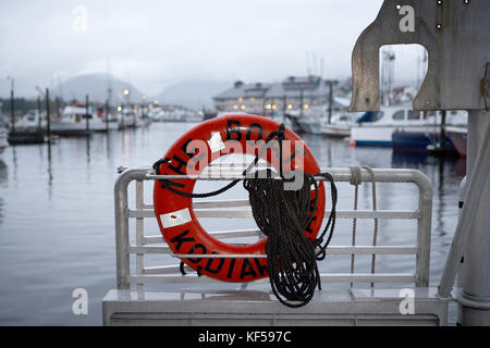 Red life preserver ou la vie anneau attaché à la rambarde de métal sur un bateau avec une corde enroulée de sauvetages d'urgence dans le cas de la noyade avec un temps brumeux Banque D'Images