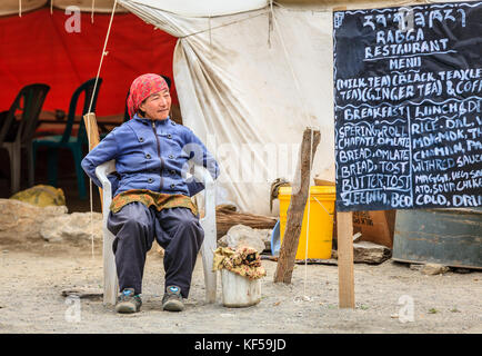 Le Ladakh, Inde, le 16 juillet 2016 : femme assise locale par le menu Se connecter d'une cantine en bordure de plateau changthang, Ladakh, Cachemire, Inde Banque D'Images