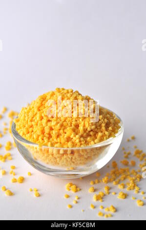 Les granules de lécithine dans bol en verre isolé sur blanc - un complément alimentaire Banque D'Images