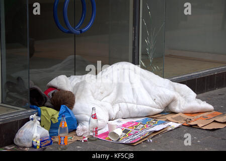 Les jeunes sans-abri Glasgow garçon qu'il dort sur le sol, dans une entrée de porte sur la rue en couette Banque D'Images