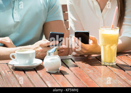 Close-up of young woman sitting on bench using mobile phone Banque D'Images