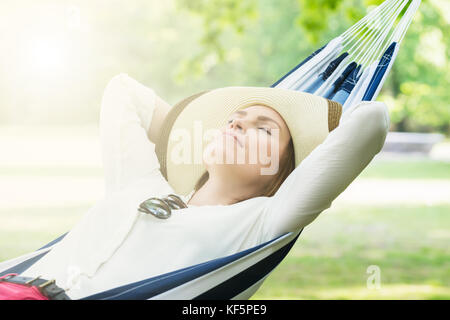 Young Woman Sleeping In Hammock At Park Banque D'Images