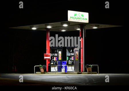 Vider les pompes de la petite station-service de la ville la nuit. Banque D'Images