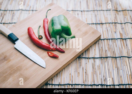 Poivre,couteau,le piment et le poivron sur une planche à découper. Légumes sur planche à découper Banque D'Images