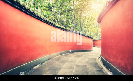 Passage des murs rouges en courbes, entouré de forêt de bambou, harmonisation des couleurs appliquées, wuhou temple à Chengdu, Chine. Banque D'Images