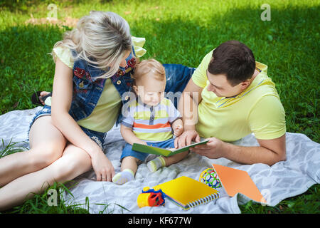 Happy Family reading book in park Banque D'Images