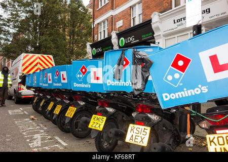 Une rangée de Domino's Pizza scooters livraison attendant dehors un Domino's restaurant dans le centre de Londres, UK Banque D'Images