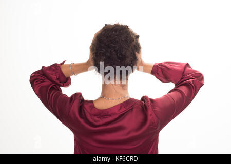 Vue arrière de la tête dans les mains d'une femme debout sur un fond blanc. Banque D'Images