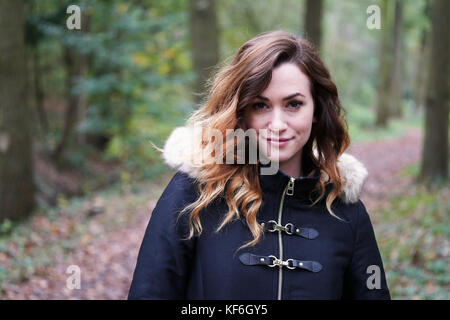 Jeune femme portant manteau d'hiver dans la forêt Banque D'Images