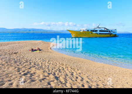 Bateau touristique sur la mer d'azur, près de plage de Zlatni rat, l''île de Brac, Croatie Banque D'Images