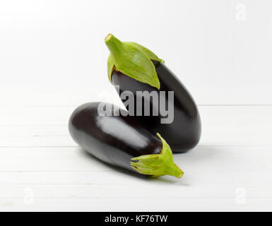 Deux aubergines fraîches sur fond de bois blanc Banque D'Images