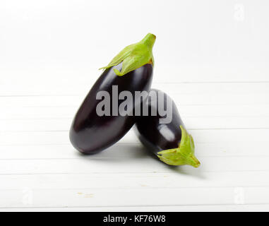 Deux aubergines fraîches sur fond de bois blanc Banque D'Images