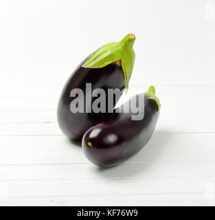 Deux aubergines fraîches sur fond de bois blanc Banque D'Images