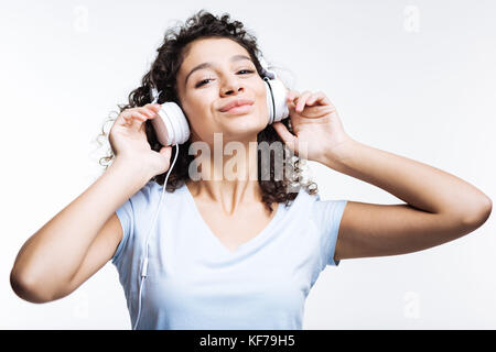 Femme joyeuse à l'écoute de chansons préférés et smiling Banque D'Images