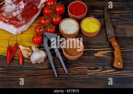 Côtes levées de porc Viande, tomate, Ail, piment, oignon, épices prêt pour un barbecue sur le plateau de schiste Banque D'Images