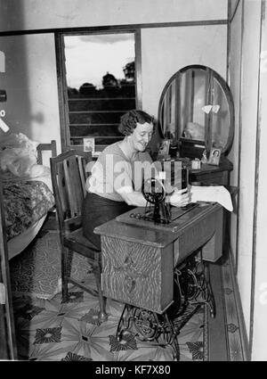 1101812 femme assis à une machine à coudre à pédale Singer, Rocklea, 1944 Banque D'Images