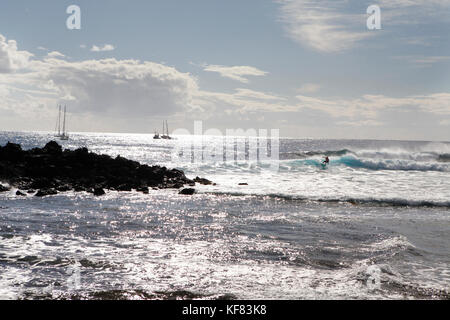 L'île de Pâques, chili, Isla de Pascua, rapa nui, un surfer dans l'eau attire une vague près de Hanga Roa Banque D'Images